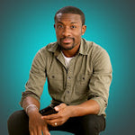 A man in an olive shirt holds a smartphone with a black Plaud Note attached against a teal background.