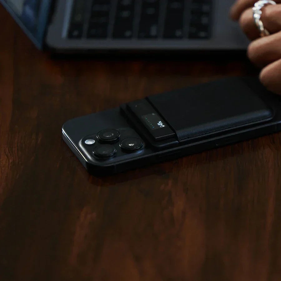 A black Plaud Note Pro is attached to the back of a smartphone on a wooden desk, its display showing a 41% battery level.